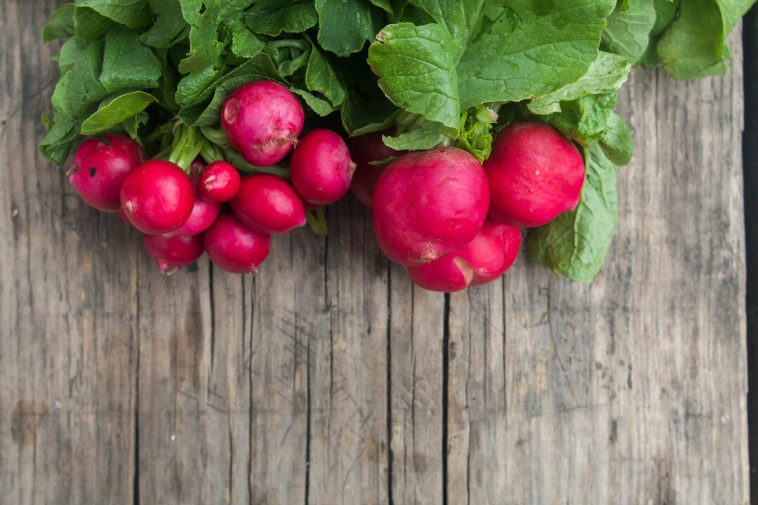 Basket of fresh spring herbs and radishes on a wooden table