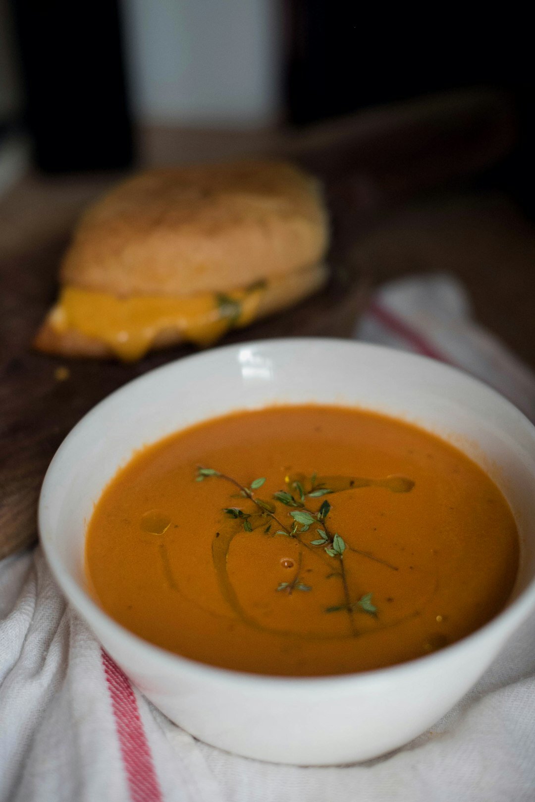 Bowl of warm winter soup with bread on a wooden table