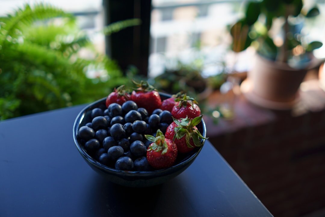 Bowl of fresh summer berries and currants on a wooden table